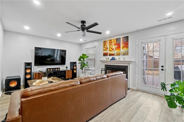 living room featuring ceiling fan, french doors, and light hardwood / wood-style flooring