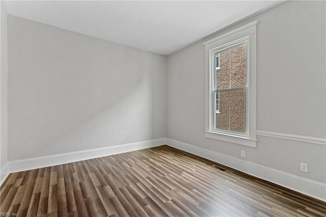 spare room with a healthy amount of sunlight and wood-type flooring