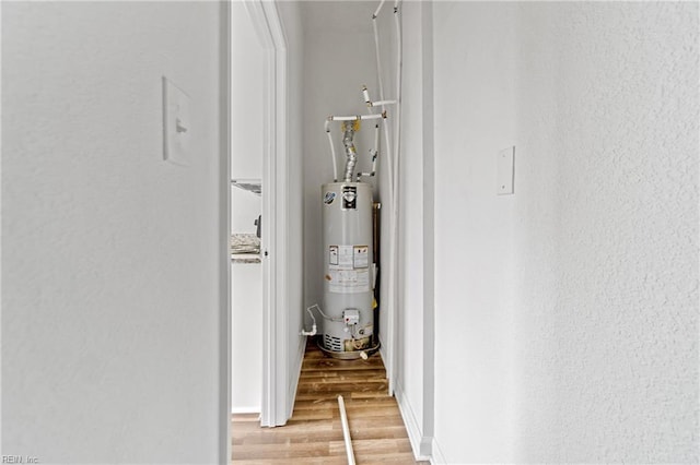 corridor featuring light hardwood / wood-style flooring and gas water heater