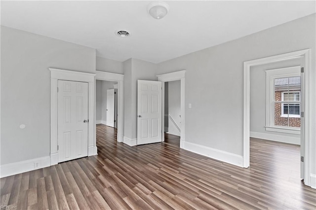 unfurnished bedroom with dark hardwood / wood-style flooring