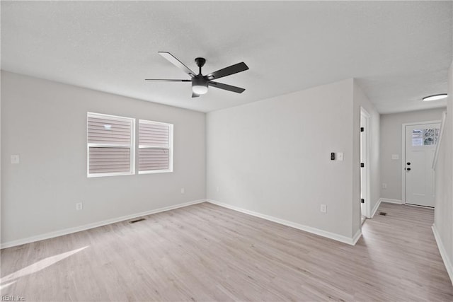 empty room featuring light hardwood / wood-style floors, a wealth of natural light, and ceiling fan