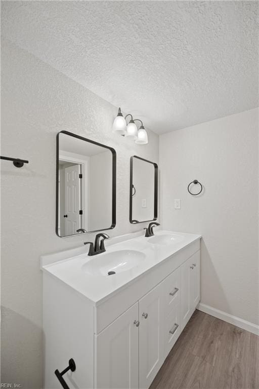 bathroom with vanity, a textured ceiling, and hardwood / wood-style flooring