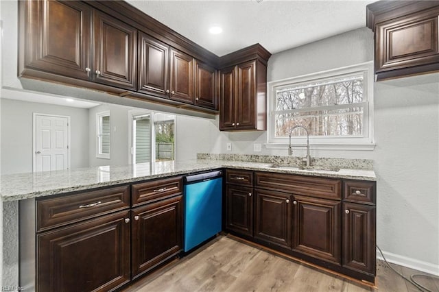 kitchen featuring kitchen peninsula, light stone counters, stainless steel dishwasher, sink, and light hardwood / wood-style flooring