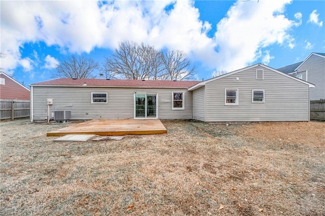 rear view of property with a wooden deck and cooling unit