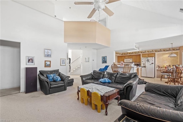 living room featuring ceiling fan, high vaulted ceiling, and light colored carpet