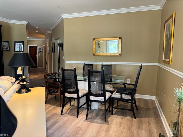 dining space with light hardwood / wood-style flooring and crown molding