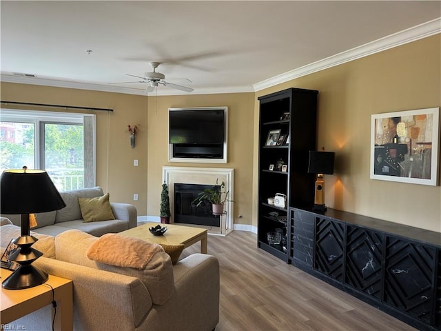 living room with hardwood / wood-style floors, ceiling fan, and crown molding