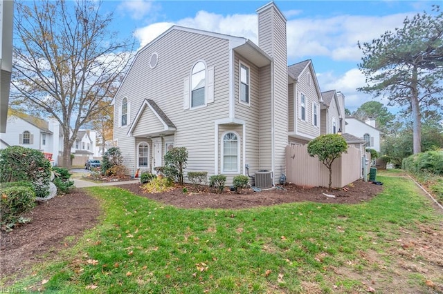 view of front of home featuring cooling unit and a front yard