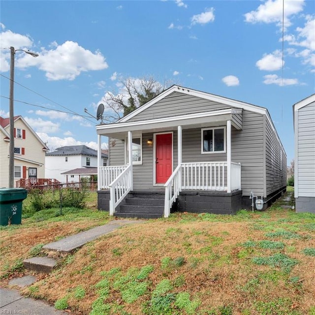 bungalow-style home with covered porch and a front lawn