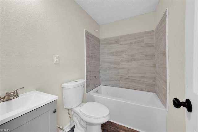 full bathroom with tiled shower / bath combo, wood-type flooring, a textured ceiling, toilet, and vanity