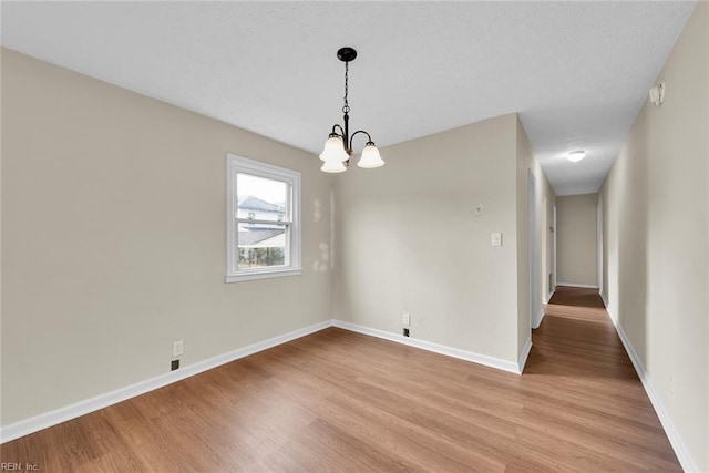 unfurnished dining area with a chandelier and light hardwood / wood-style floors