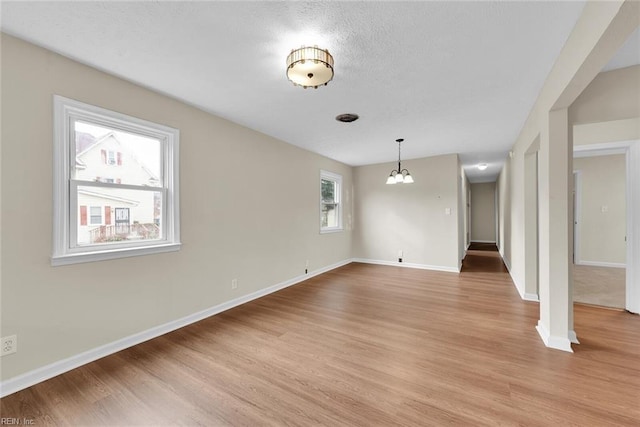 unfurnished living room featuring light hardwood / wood-style flooring and a chandelier