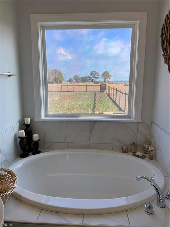 bathroom with tiled bath and a wealth of natural light