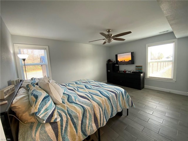 bedroom with ceiling fan and multiple windows