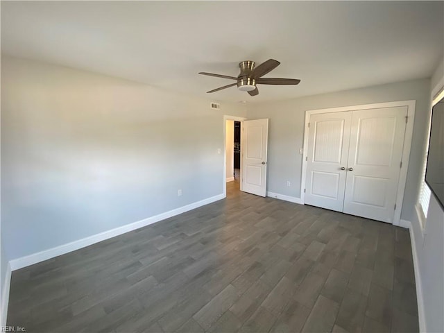 unfurnished bedroom with ceiling fan, dark hardwood / wood-style floors, and a closet