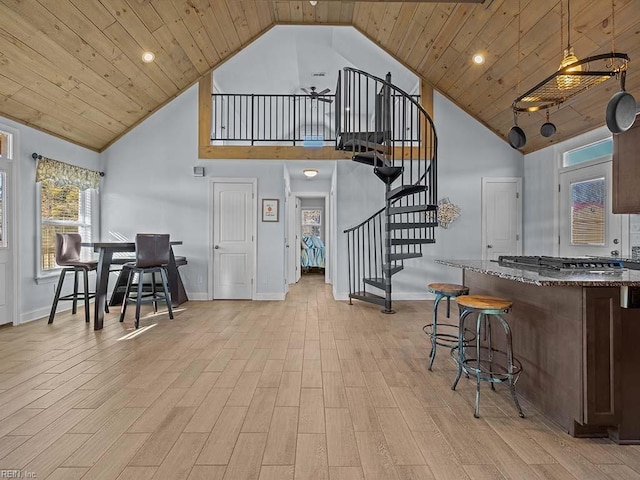 interior space featuring stainless steel gas cooktop, wood ceiling, stone countertops, and high vaulted ceiling