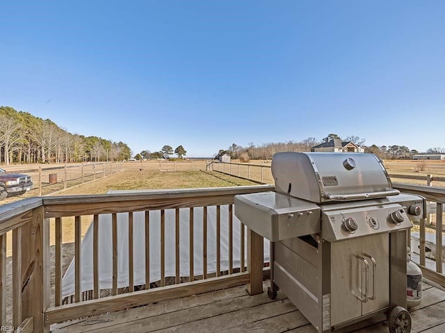 wooden terrace with a grill and a rural view