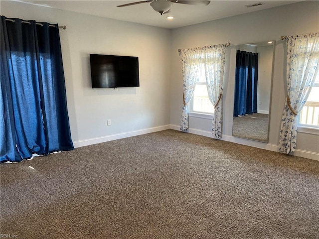 carpeted spare room featuring ceiling fan