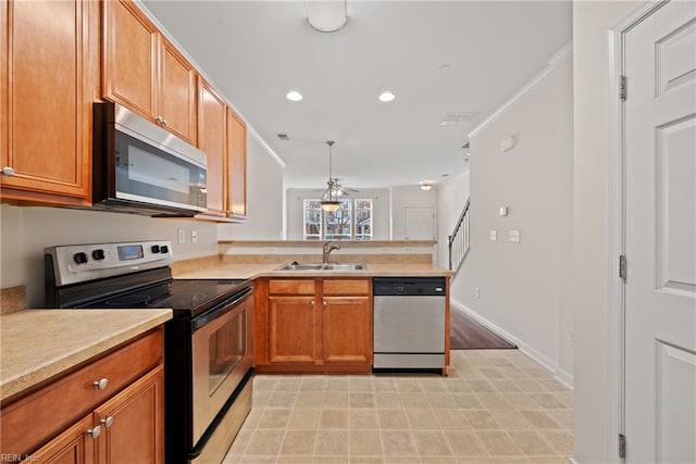 kitchen featuring ceiling fan, sink, kitchen peninsula, decorative light fixtures, and appliances with stainless steel finishes