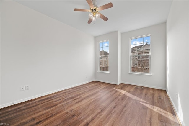 spare room with ceiling fan, baseboards, and wood finished floors