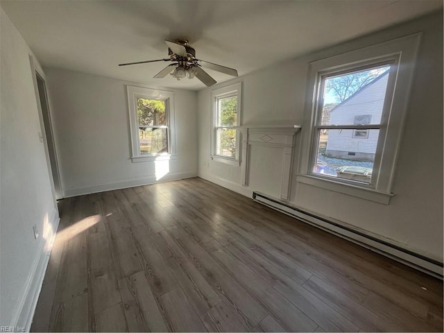 spare room featuring hardwood / wood-style flooring, ceiling fan, and a baseboard heating unit