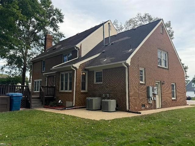 back of property featuring a lawn, central AC unit, and a deck