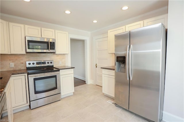 kitchen featuring backsplash, appliances with stainless steel finishes, dark stone counters, light tile patterned floors, and ornamental molding