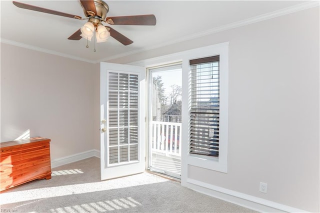 carpeted spare room with ceiling fan and crown molding