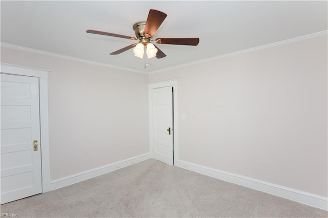 empty room featuring light carpet, crown molding, and ceiling fan