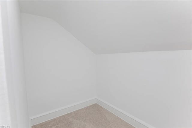 interior space featuring carpet flooring and vaulted ceiling