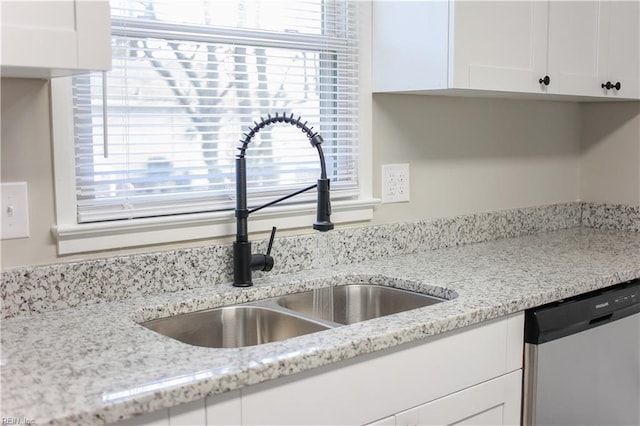 kitchen featuring dishwasher, white cabinetry, sink, and a wealth of natural light