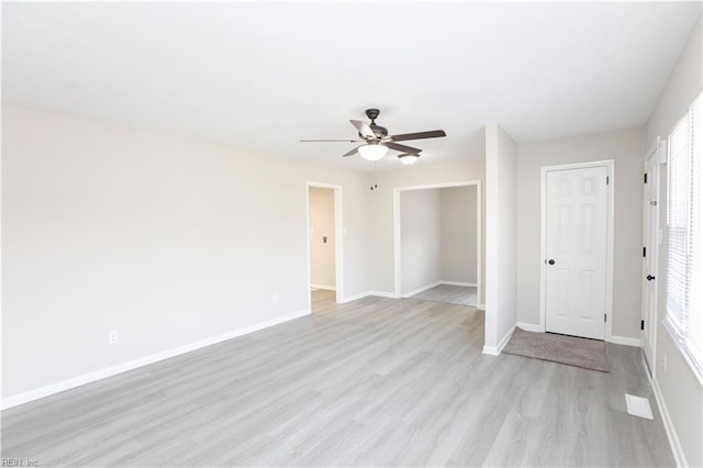 unfurnished room featuring a wealth of natural light, light wood-type flooring, and ceiling fan