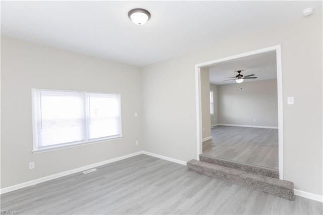 empty room with ceiling fan and hardwood / wood-style flooring