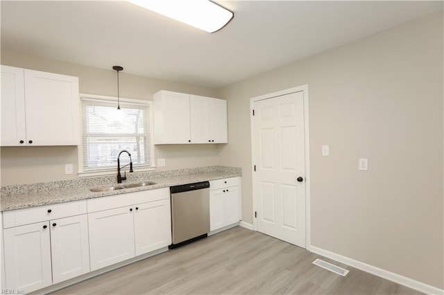 kitchen featuring white cabinetry, dishwasher, sink, hanging light fixtures, and light wood-type flooring