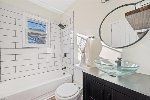 full bathroom featuring tiled shower / bath combo, toilet, and vanity