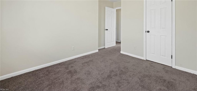 unfurnished bedroom with a closet and dark carpet