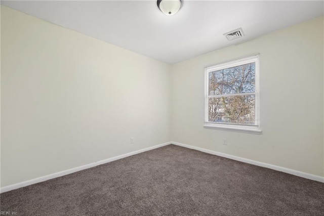 spare room with dark colored carpet