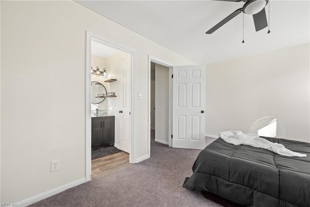 carpeted bedroom with ensuite bathroom and ceiling fan