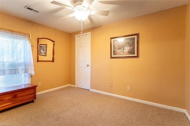 unfurnished bedroom featuring carpet, ceiling fan, and a textured ceiling