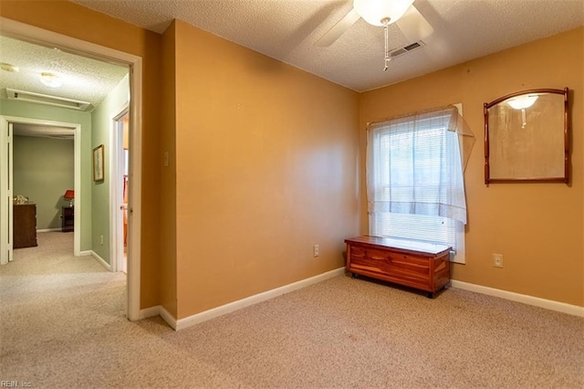 carpeted empty room featuring ceiling fan and a textured ceiling