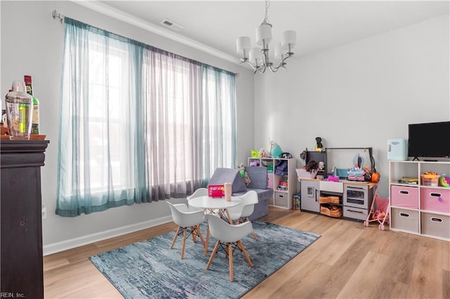 recreation room with an inviting chandelier and light hardwood / wood-style floors