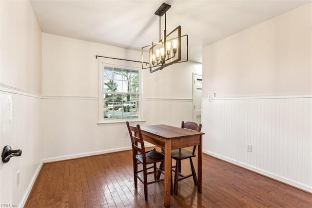 dining area featuring dark hardwood / wood-style floors and an inviting chandelier