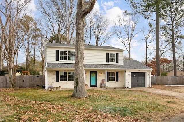 view of property featuring a front yard and a garage