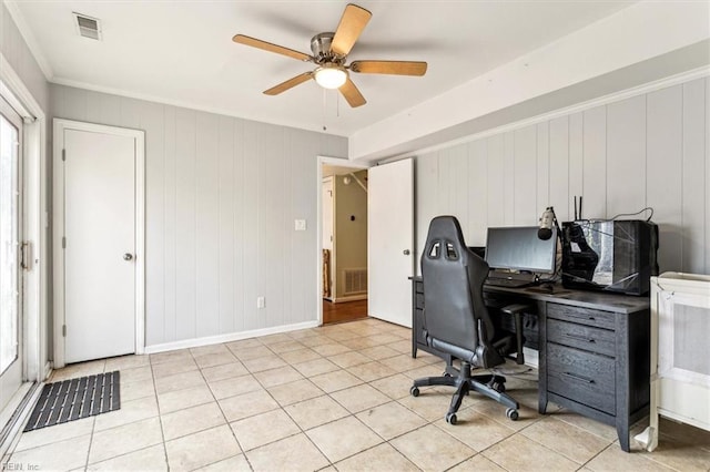 home office featuring ceiling fan, light tile patterned floors, and wooden walls