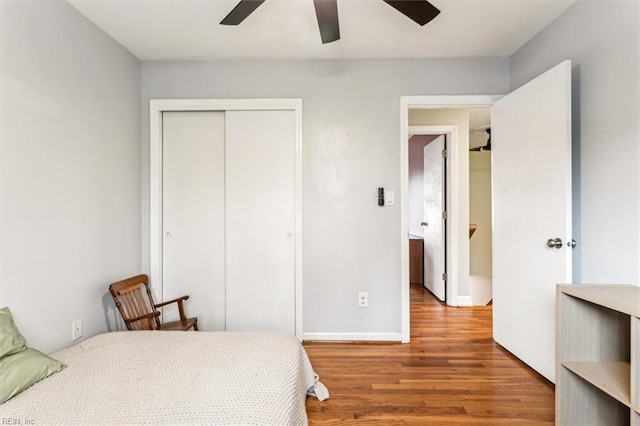 bedroom with ceiling fan, wood-type flooring, and a closet