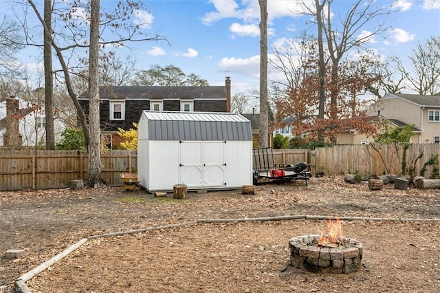 view of yard with a storage shed and a fire pit