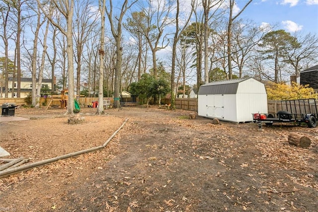 view of yard with a playground and a storage shed