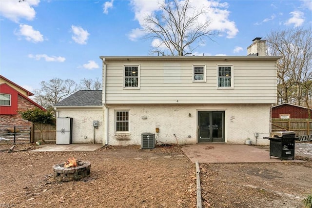 back of property with central air condition unit, an outdoor fire pit, and a patio