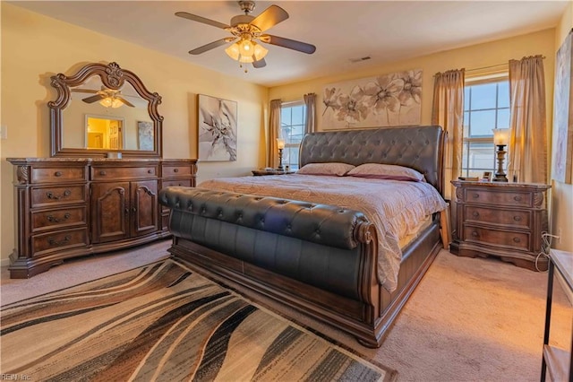 carpeted bedroom with ceiling fan and multiple windows