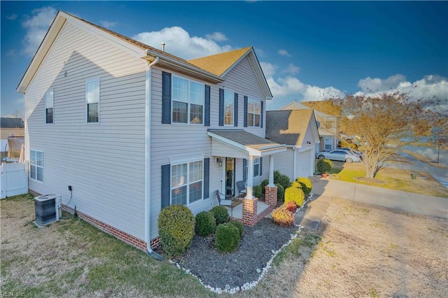 view of front of home with central AC unit, a porch, and a front lawn